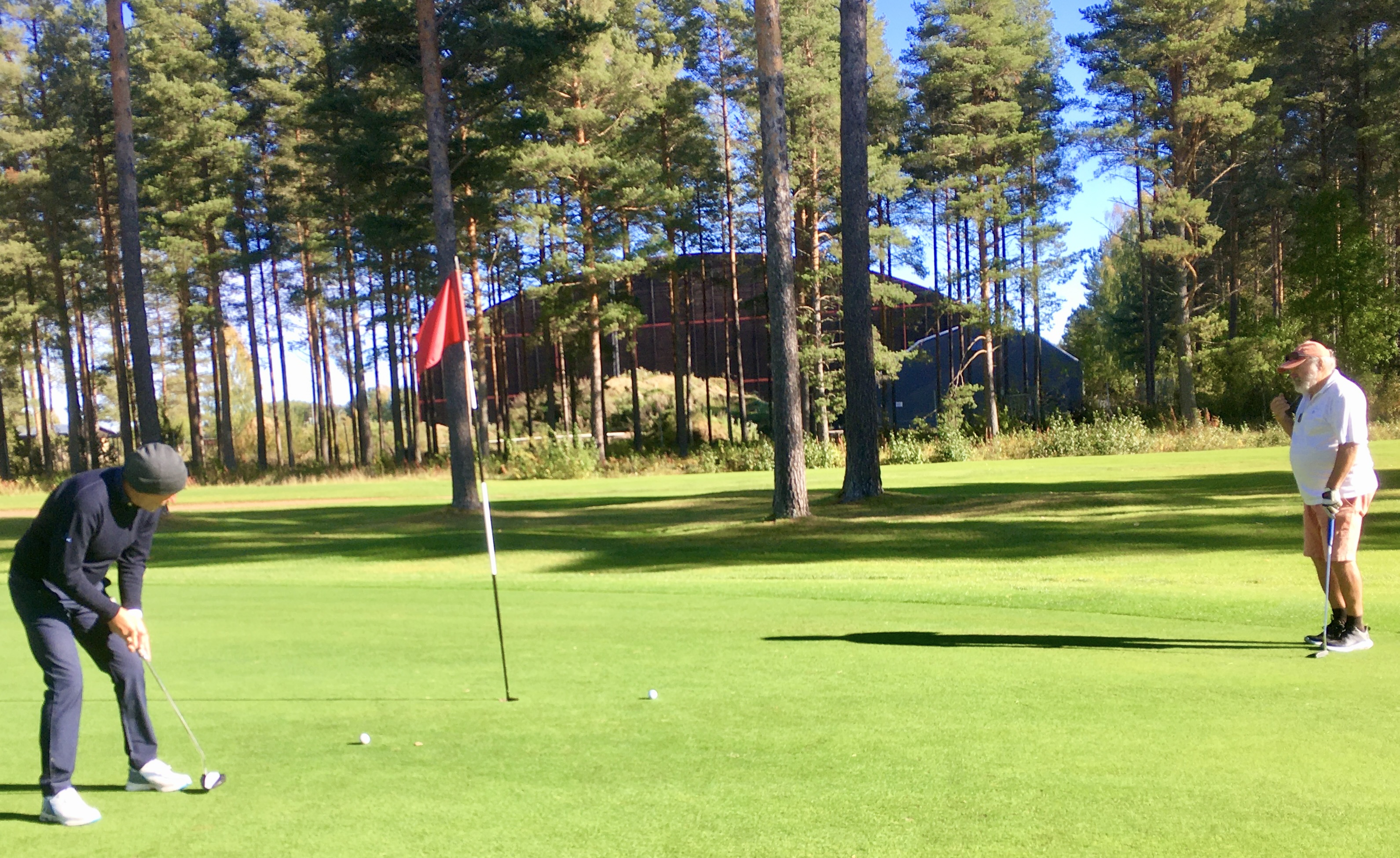 Segraren Peter Johansson sänker sin putt för par på hål 17 under överinseende av Ulf Rory Haak.